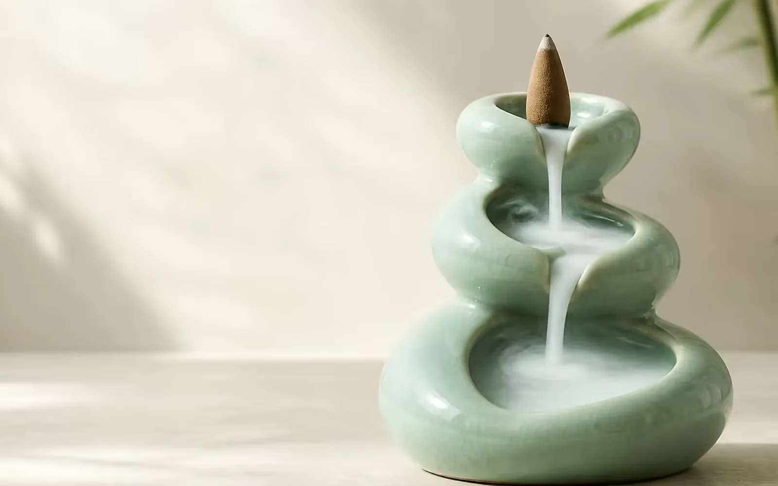 Agarwood backflow incense cone burning, smoke pouring down over the burner