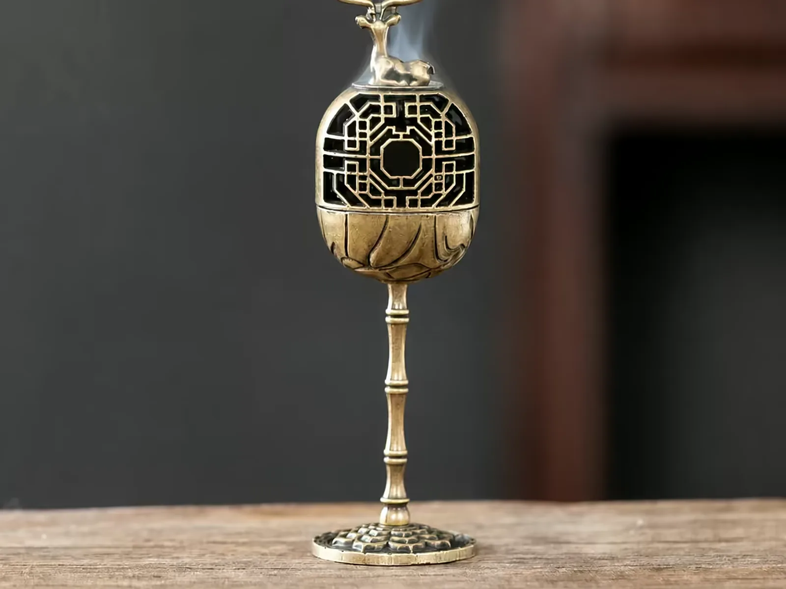 Solid brass stemmed censer with smoke rising through the pierced dome