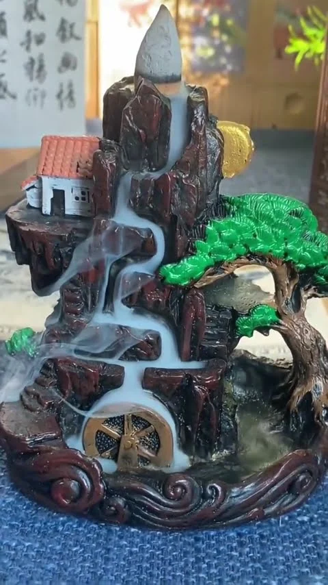 Backflow incense cones burning, with smoke running down over the burner