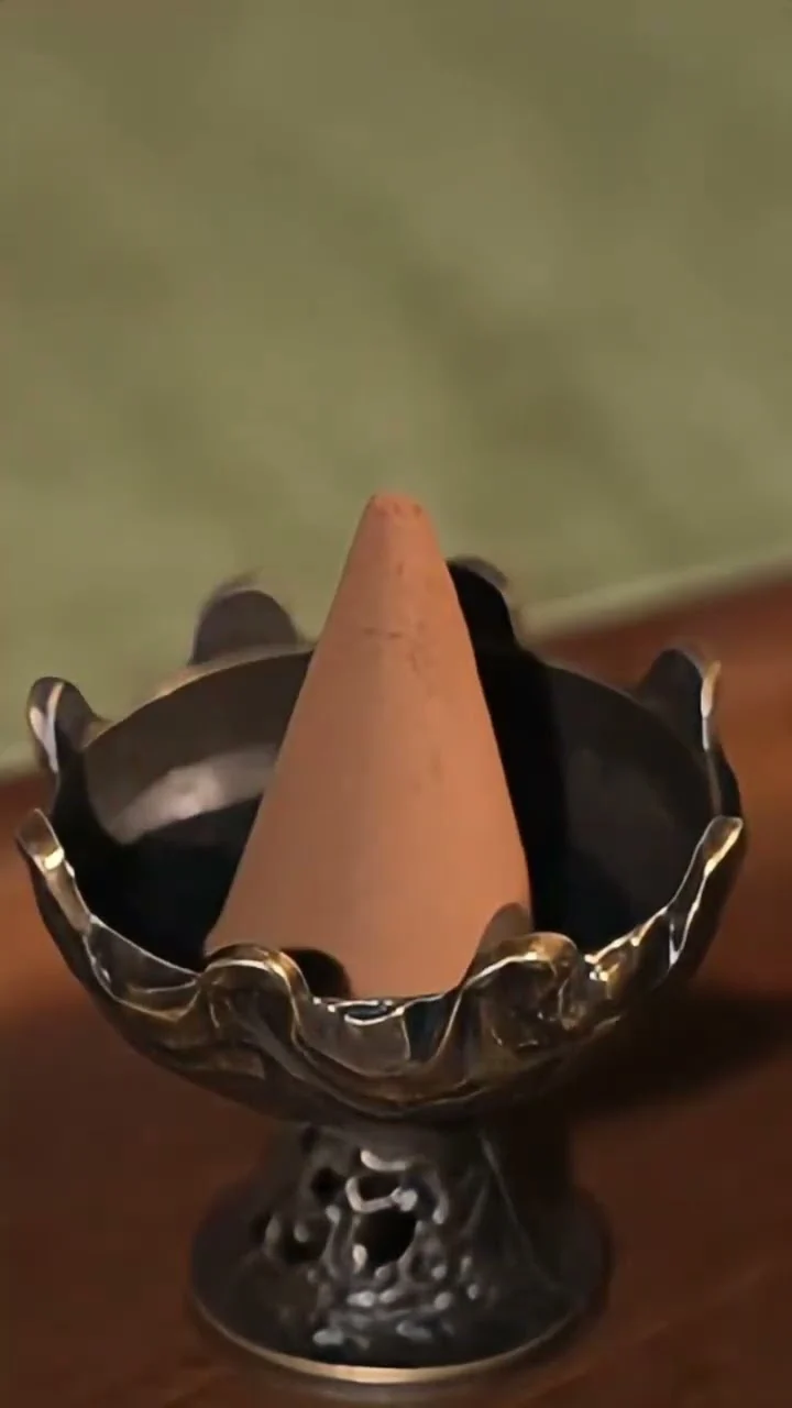 A cone alight in a mabkhara-style heat-resistant burner, the format most Gulf buyers use