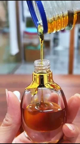 Oud oil being filled into perfume bottles ready for wholesale packing