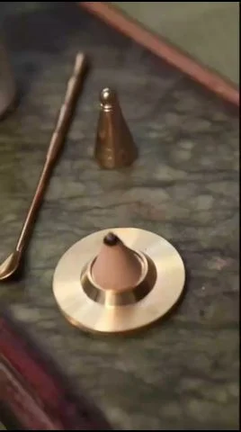 Powder pressed into a brass mould and released as a clean shape, the same action as an incense seal kit